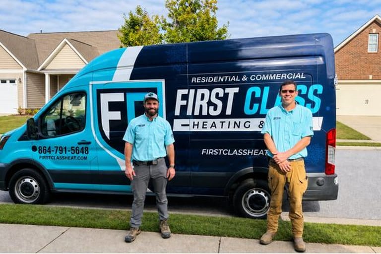 First Class Heating and Air technicians standing in front of the branded service van in Greenville SC